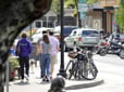 Photo of a busy sidewalk in downtown gresham with people walking past bikes and cars