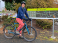 Man with bike standing beside way-finding sign showing the Wy'East trail 