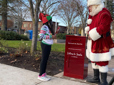 A young girl talks to Santa on the Gresham Arts Plaza while mailing her letter to the North Pole.