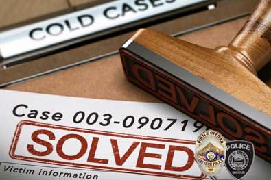 A graphic illustration titled Cold Cases with a large wooden stamp on a wooden desk that reads &quot;Case Solved&quot; with stamped case files next to it. The Gresham Police Department badges are set in the right-hand corner.