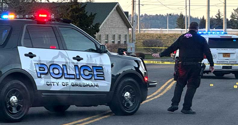 Officer Adam stands by his police car as he helps secure a shooting crime scene in North Central Gresham.